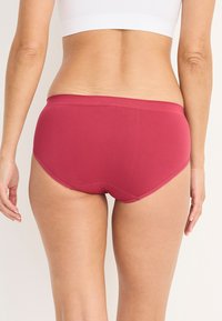 Frambozenkleurige katoenen slip met een gladde tailleband, een middelhoog snit en een naadloos ontwerp, met een effen kleur en minimale stikdetails.