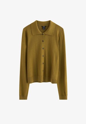 Sennepsgul cardigan med bred krave, frontlukning med knapper, lange ærmer og ribbet kant. Fremstillet af et blødt strikkemateriale.