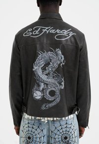 Black leather jacket with a large gray dragon graphic on the back and "Ed Hardy" text; features a collared design and adjustable waist straps.