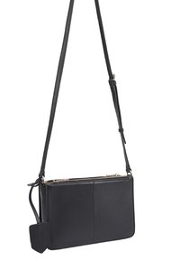 Zwart leren schoudertas met een gladde textuur, ritssluiting en een afneembare schouderband. Beschikt over een rechthoekige vorm en een klein label.