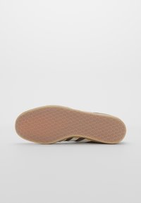 Suela de zapato con un patrón de panal, material de goma en color marrón claro con un borde beige. Diseñada para proporcionar tracción y soporte.