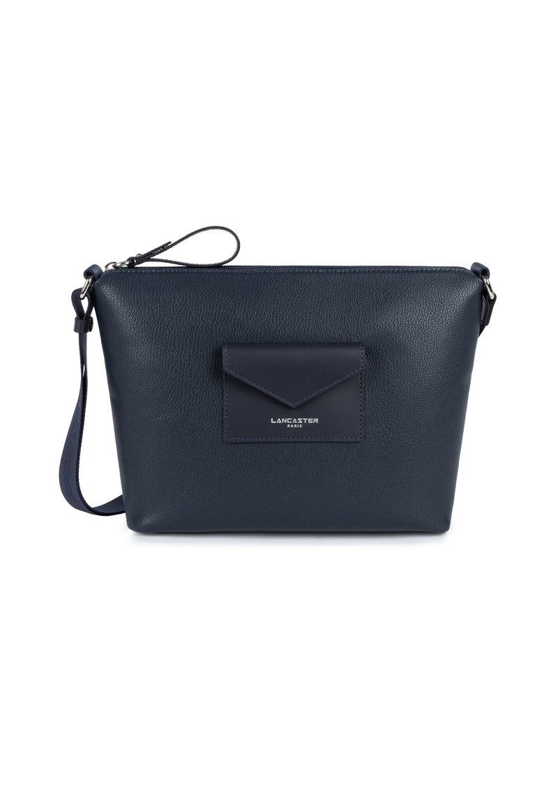 Sac pour épaule en cuir bleu marine avec une finition texturée, présentant une poche frontale à rabat et une sangle réglable. Fermeture zippée en haut.