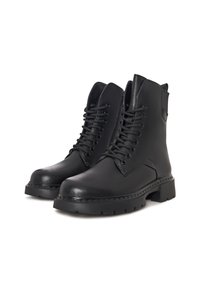 Botas de cuero negro hasta el tobillo con diseño de cordones, suelas de goma gruesas y detalles texturizados. Presentan una punta redonda y un collar acolchado.