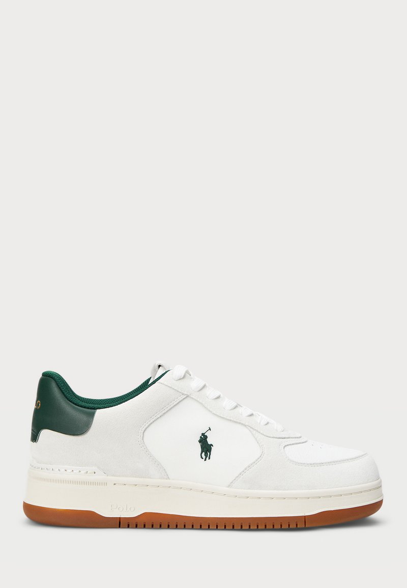 Baltie apavi ar zaļiem akcentiem. Izgatavoti no zamšādas un ādas, tiem ir noapaļota purna forma, plakanas auklas un gumijas zole ar teksturētu saķeri.