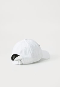 White baseball cap made of cotton with a curved brim, adjustable strap at the back, and a smooth texture. No visible patterns or logos.