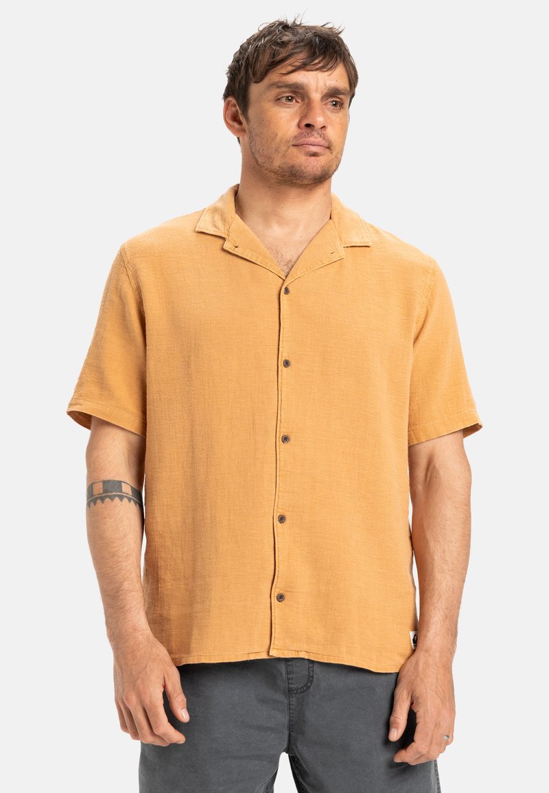 Short-sleeve, button-up shirt in mustard yellow fabric, featuring a textured finish, spread collar, and brown buttons.