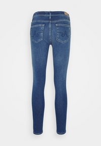 Slim-fit jeans i mörkblå denim. Har två bakfickor med sömnadsdetaljer och en läderetikett vid midjan. Slät textur.