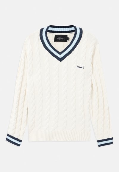 Kremna pletena jopica s kabelskim vzorcem, zasnovo v obliki črke V ter temno modrim in svetlo modrim črtastim obrobami na ovratniku in manšetah.