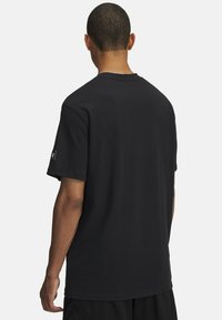Sort bomulds T-shirt med klassisk rund hals, korte ærmer og en afslappet pasform. Har et lille logo på venstre ærme.