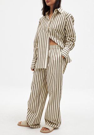 Gestreepte pyjama set in beige en bruin, met een knoopdetail overhemd in een ontspannen pasvorm en bijpassende losse broek met een elastische tailleband.