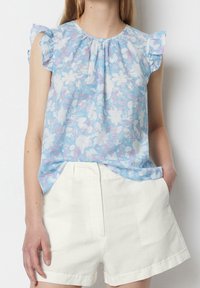 Hemdbluse mit kurzen Ärmeln in Hellblau mit floralem Muster in Weiß und Pink, ausgestattet mit einem gerafften Hals und Rüschen an den Ärmeln.