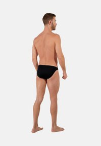 Zwarte zwemshorts gemaakt van gladde stof, met een klassieke snit, een minimalistisch ontwerp en zonder zichtbare patronen of accenten.