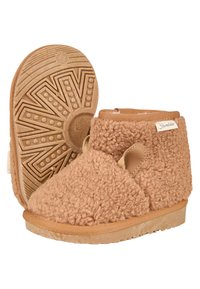 Braune, plüschige Hausschuhe mit einer weichen, strukturierten Oberfläche und kurzer Höhe. Sie verfügen über eine Gummisohle mit einem gemusterten Profil und einem seitlichen Ausschnitt.