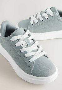 Lyseblå ruskindsneakers med hvide snørebånd; har runde tæer, perforerede detaljer på siderne og hvide gummisåler.