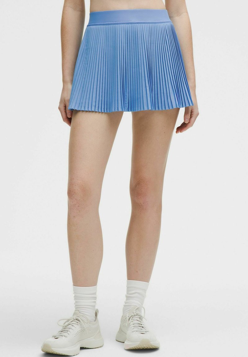 Falda azul con plisados y una cinturilla ancha y suave. Hecha de tela ligera, presenta una silueta acampanada y plisados texturizados.