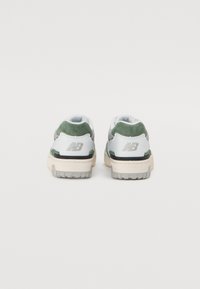 Las zapatillas blancas y verdes cuentan con una parte superior de ante y malla, con una suela exterior de goma texturizada. Marca plateada en el talón. Cierre clásico con cordones.