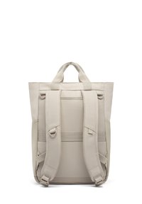 Beige színű hátizsák, téglalap alakú, párnázott vállpántokkal, dupla felső fogantyúval és oldalsó zsebekkel a tárolás érdekében. Sima textúrájú.