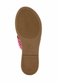 Suola della scarpa con una superficie in gomma marrone testurizzata, caratterizzata da un motivo geometrico e un logo circolare. Bordo in tessuto intrecciato colorato in rosa.