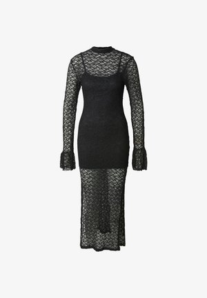 Mustapitsi mekko, jossa pitkät hihat ja korkea kaulus. Vartalonmyötäinen siluetti, jossa on läpikuultava hame sivuhalkiolla ja liehuvat kalvosimet.