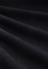 Tela de algodón negra con una textura suave, con suaves pliegues y una superficie uniforme. Sin patrones ni hardware visible.