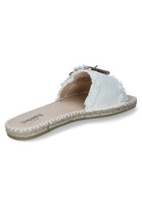 White fabric slide sandal with frayed edges, brown accent hardware, and woven jute sole. Soft texture and open-toe design.