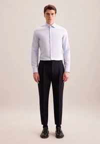 Lichtblauw overhemd met lange mouwen en een button-down kraag, gecombineerd met donkere broek en zwarte schoenen. Gladde textuur, op maat gemaakte pasvorm.