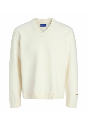 Pull en maille V en blanc cassé avec des bords côtelés aux poignets et à l'ourlet, arborant un petit logo brodé sur le poignet gauche.