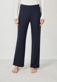 Pantaloni larghi navy con texture a coste verticali e vita elasticizzata, realizzati in tessuto morbido. Presentano una vestibilità comoda e lunghezza intera.