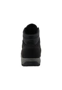 Bota de senderismo negra con cuello acolchado en el tobillo, costuras reforzadas y suela de goma gris vista desde la parte posterior sobre un fondo blanco.
