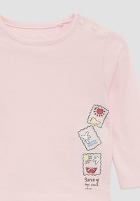 Helles rosa langärmliges Babyshirt mit Druckknöpfen an der Schulter und drei kleinen, bunten Sommer-Themen-Patches auf der Vorderseite.