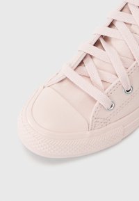 Rosa kanvas sneakers med gummitåhette, teksturert gummisåle og øyer. Har sydd detaljer og flate lisser.
