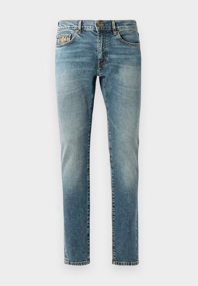 Light blue denim jeans with a straight fit, five pockets, brass hardware, and subtle fading on the legs. Classic stitching detail.