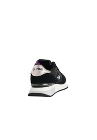 Chaussure de sport noir et blanc avec doublure intérieure violette, accents scintillants, « SUN68 » sur le talon, et logo « AX » sur le côté, vue arrière en angle.