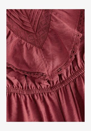 Burgundi värvi kleit, millel on tekstuuriga kangas, volangiga ääred ja pitsdetailid kaeluse ja rinnaosas, ning kokkuvõtatu elastne vöökoht.