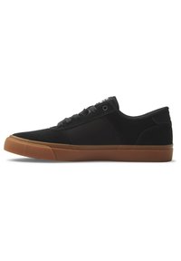 Svart sneakers i canvas med gummisula. Har en låg profil, snörningsdesign och texturerade detaljer på sulan.