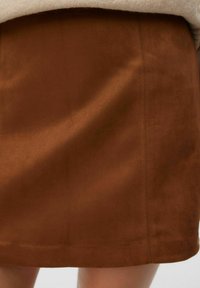 Bruine suède mini-rok met een gladde textuur, voorzien van een rechte snit en subtiele naaddetails.