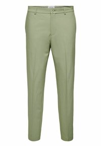 Pantalones verde claro hechos de un tejido suave, con cremallera, dos bolsillos frontales y un corte entallado. Detalles de costura mínimos visibles.