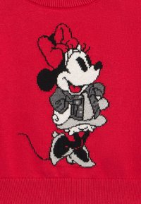 Κόκκινο πλεκτό πουλόβερ με γκρι και μαύρο καρτούν ποντίκι που φοράει κόκκινο φιόγκο και μοτίβο ρούχο, με απαλή, υφή υφή.