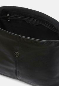 Bolso de cuero negro con una textura suave. Presenta un cierre de presión magnético y un bolsillo interior con cremallera, destacando un diseño minimalista.