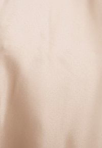 Tessuto satin beige con una texture liscia e una leggera lucentezza, caratterizzato da un colore uniforme senza motivi o accenti.