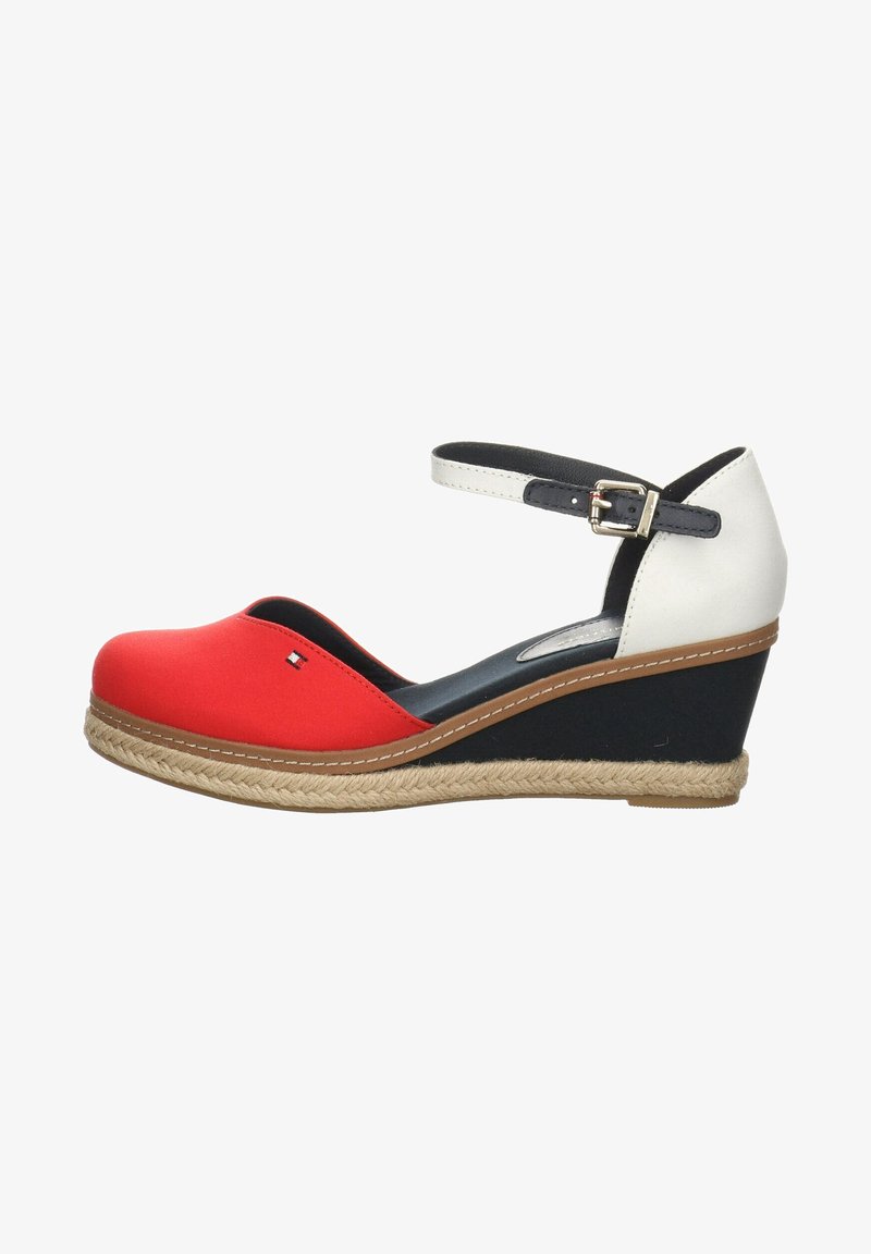 Zapato cuña rojo y blanco con correa en el tobillo, suela de yute estilo espadrille, punta redonda y acentos negros. Parte superior de tela suave y plantilla acolchada.