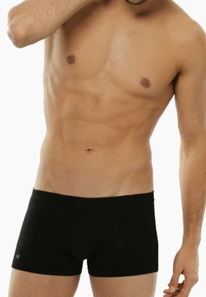 Gli slip boxer neri in cotone presentano una vestibilità aderente, un elastico in vita e dettagli di cucitura minimi. Il tessuto ha una consistenza liscia.