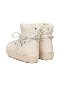 Beige zimní boty do kotníku s polstrovaným textilním svrškem, lesklým spodním materiálem, šněrováním v přední části a plochou texturovanou gumovou podrážkou.