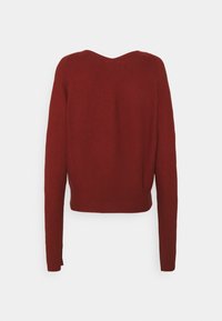 Red knitted sweater with long sleeves and a rounded neckline, featuring a textured fabric and a cropped back design.