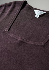 Fioletowy dzianinowy top z kwadratowym dekoltem i krótkimi rękawami, wykonany z miękkiego materiału. Metka z napisem "THE SET", rozmiar M, wyprodukowany w Bangladeszu.