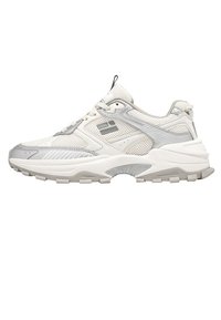Zapatilla deportiva en gris y blanco con una parte superior de malla y sintético, suela redondeada, acentos texturizados y cierre con cordones.