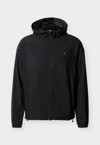 Μαύρο αδιάβροχο μπουφάν με φερμουάρ μπροστά, ρυθμιζόμενη κουκούλα και ελαστικές μανσέτες. Διαθέτει διακριτικό λογότυπο στο στήθος και ελαφρύ ύφασμα.