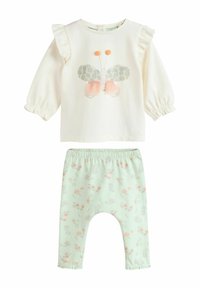 Twee-delig outfit met een crèmekleurig langemouwen top met een vlinderontwerp en mintgroene broek met bloemenpatronen en frullen accenten.