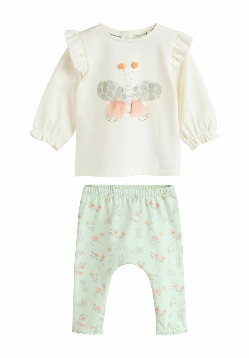 Twee-delig outfit met een crèmekleurig langemouwen top met een vlinderontwerp en mintgroene broek met bloemenpatronen en frullen accenten.