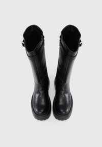 Botas pretas de couro até ao joelho com sola plana, ligeira textura, e detalhe de fivela na borda superior. Acabamento liso sem padrões visíveis.